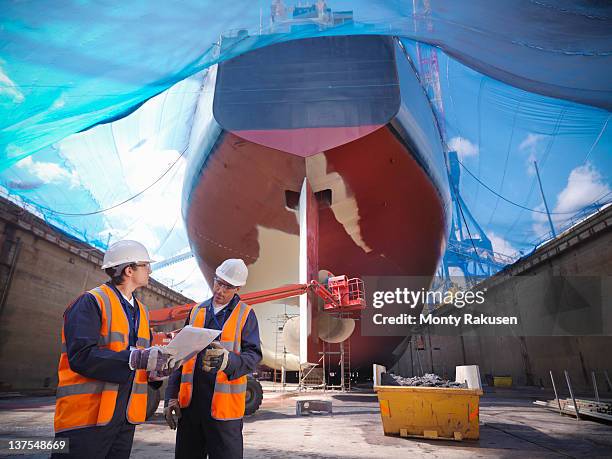shipbuilding in dry dock - ship building stock-fotos und bilder
