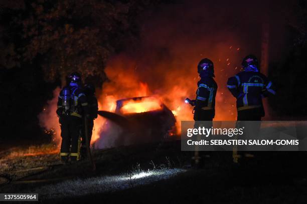 Firefighters extinguish a car on fire in Nantes, western France on early July 1 four days after a 17-year-old man was killed by police in Nanterre, a...