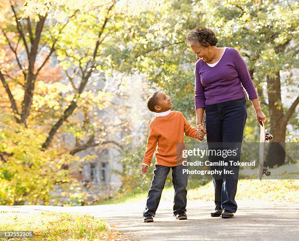 grandmother and granson walking in park smiling - 孫子 個照片及圖片檔