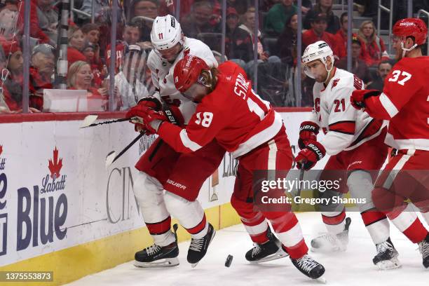 Marc Staal of the Detroit Red Wings battles for the puck against Jordan Staal of the Carolina Hurricanes during the first period at Little Caesars...