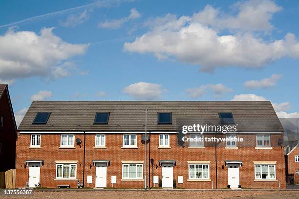 row of terraced houses with white doors - rijhuis stockfoto's en -beelden