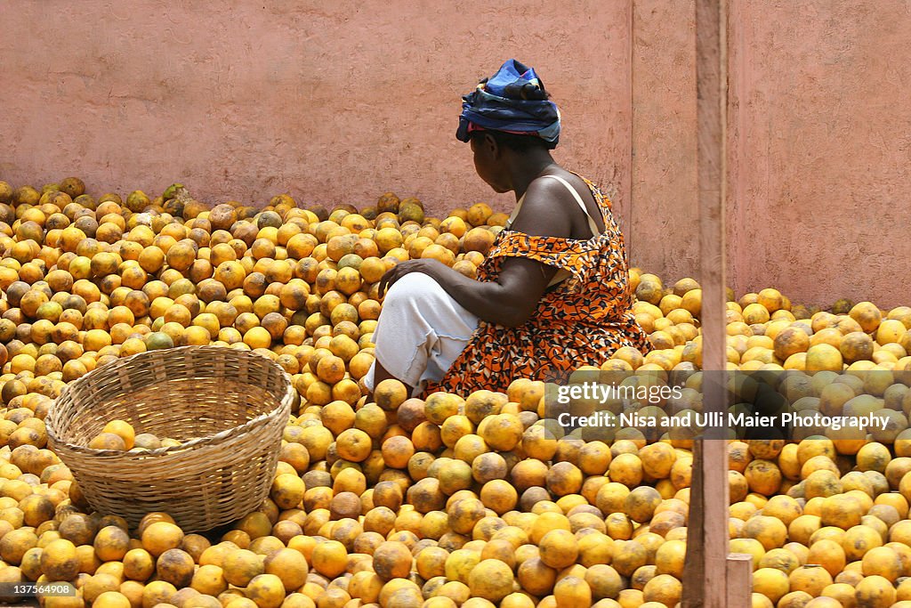 Woman selling oranges at market in Ghana