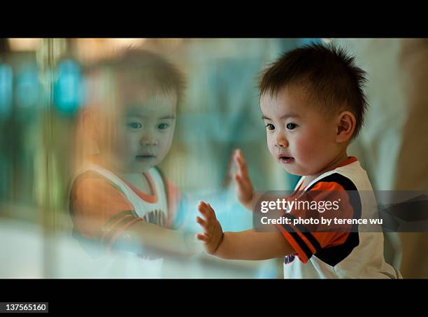 boy curiously looking at his own reflection - boy letterbox stock-fotos und bilder