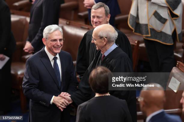 Attorney General Merrick Garland greets Supreme Court Associate Justices Stephen Breyer and Elena Kagan and Chief Justice John Roberts before...