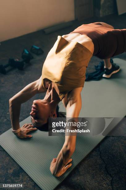 beautiful fit woman doing a backbend bridge on a yoga mat - serbia bridge stock pictures, royalty-free photos & images