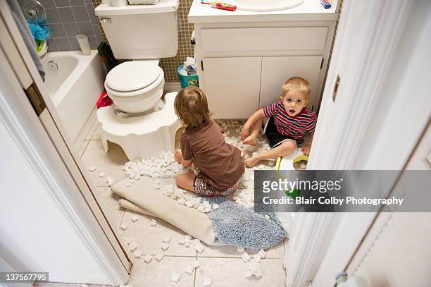 boys making mess in bathroom - misbehaving children stock pictures, royalty-free photos & images