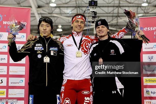 Keiichiro Nagashima of Japan, Dmitry Lobkov of Russia and Tucker Fredricks pose for photographers on the winner's podium after the men's 500 meter...