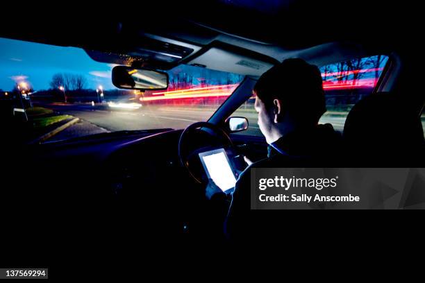 Man using at tablet and mobile phone in car