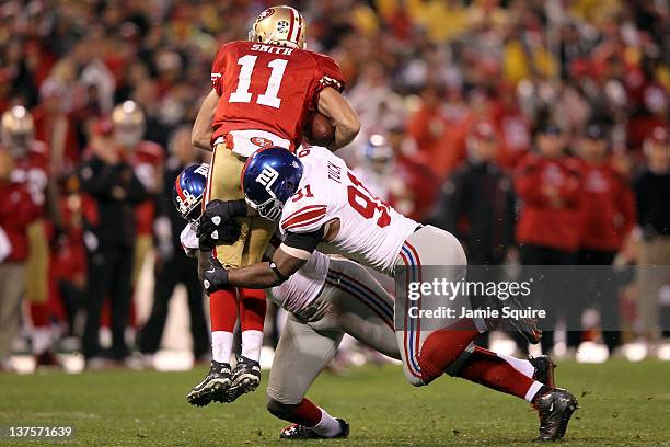 Alex Smith of the San Francisco 49ers is sacked by Justin Tuck and Jason Pierre-Paul of the New York Giants in the third quarter during the NFC...