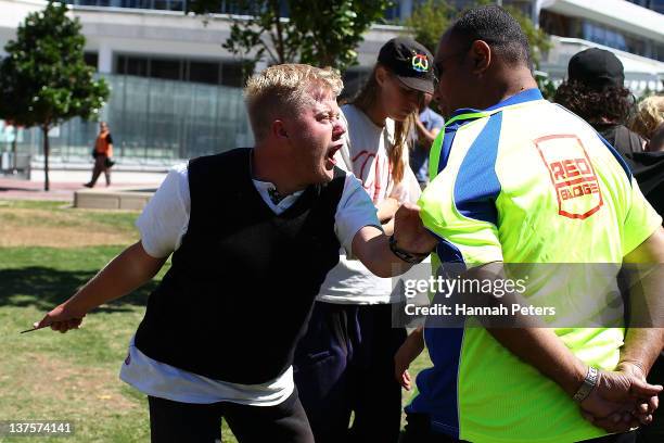 Protestor tries to pull security away from his tent at Aotea Square on January 23, 2012 in Auckland, New Zealand. More than 30 police officers were...