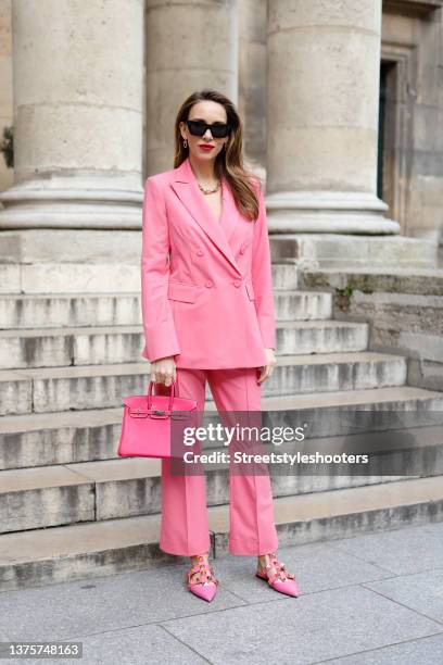 Influencer Alexandra Lapp wearing a pink double breasted blazer and matching pants by Riani, gold City HardWear jewelry by Tiffany & Co., a pink...