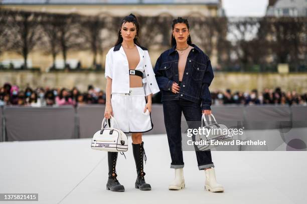 Angela Rozas Saiz wears gold large pendant earrings from Dior, a white V-neck / beige tulle / cropped t-shirt from Dior, a white short sleeves open...