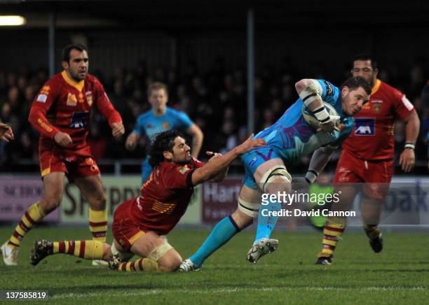 James Phillips of Exeter Chiefs burst through to score Exeter's third try as Jean-Pierre Perez of Perpignan tries to haul him back during the Amlin...