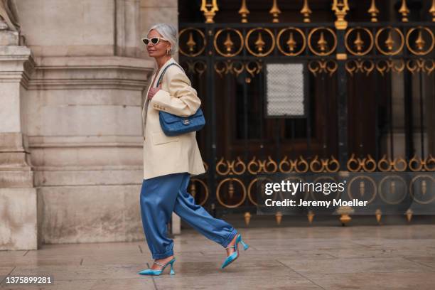 Grece Ghanem seen wearing beige blazer with statement sleeves, blue ballon pants, silk blouse, denim blue Chanel bag, turquoise Amina Muaddi heels,...