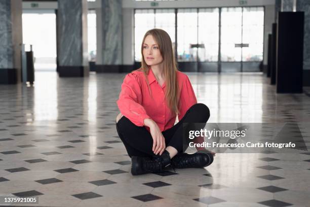 woman sitting on floor lisbon metro station - fashion woman floor cross legged stock pictures, royalty-free photos & images