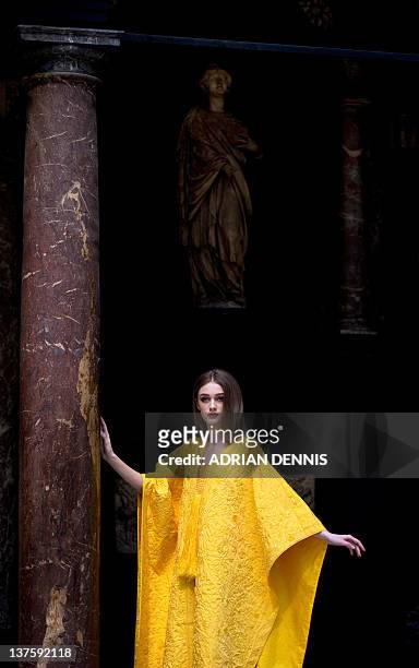 Bianca Gavrilas models a hand-embroidered cape made from the naturally golden silk of the Orb spider during a photocall at the Victoria & Albert...