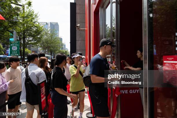 Customers enter the first outlet of US burger restaurant chain Five Guys in the Gangnam District of Seoul, South Korea, on Saturday, July 1, 2023....