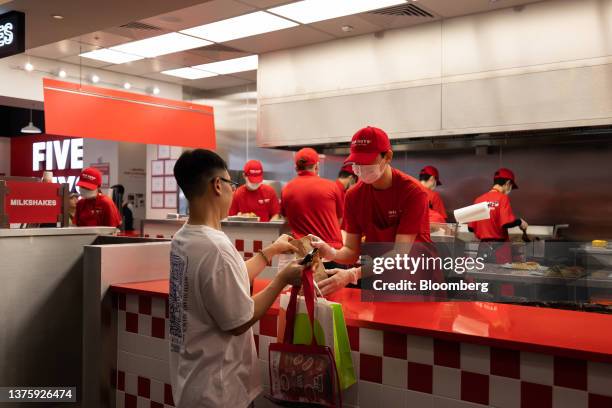 An employee assists a customer inside the first outlet of US burger restaurant chain Five Guys in the Gangnam District of Seoul, South Korea, on...