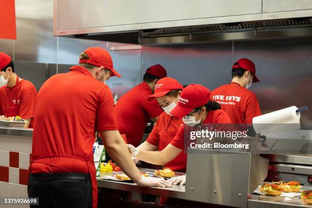 Employees prepare burgers at the first outlet of US burger restaurant chain Five Guys in the Gangnam District of Seoul, South Korea, on Saturday,...