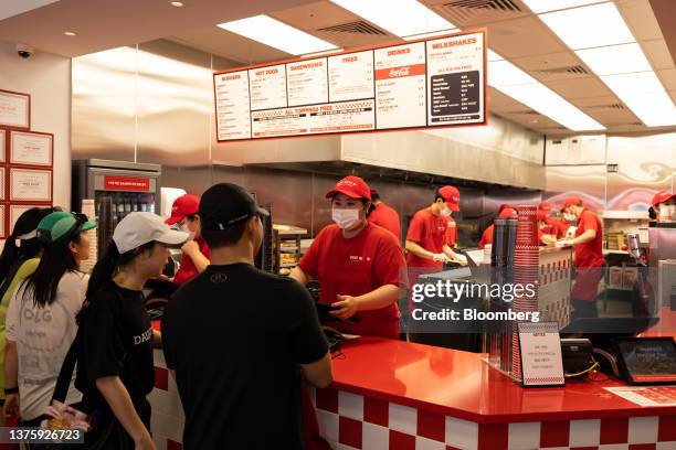 An employee attends to customers inside the first outlet of US burger restaurant chain Five Guys in the Gangnam District of Seoul, South Korea, on...