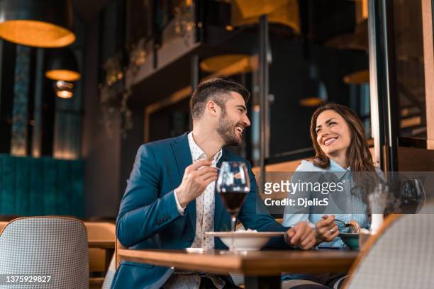 happy couple eating lunch together in a restaurant. - young couple dining stock pictures, royalty-free photos & images