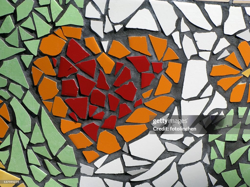 Mosaic of a red and orange heart on green and white tile