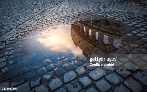 coliseum of rome reflected in rain water - cobblestone puddle stock pictures, royalty-free photos & images