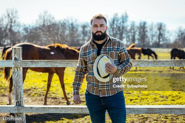 das porträt eines jungen bauern, der auf seinem hof steht. - modern cowboy stock-fotos und bilder