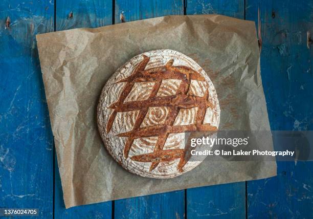 littlebourne, kent, england, uk. 27 october 2021. fresh sourdough bread on baking parchment. - scoring bread stock pictures, royalty-free photos & images