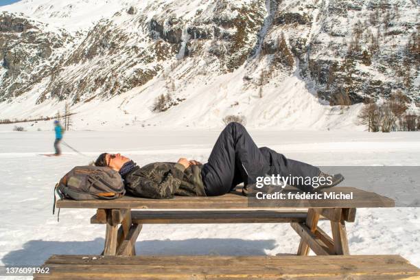 a woman rests lying on a picnic table next to a cross-country ski trail in winter - cross country skiing bildbanksfoton och bilder