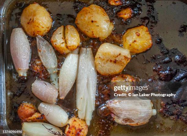 littlebourne, kent, england, uk. 23 january 2022. potatoes and shallots in a roasting tray. - shallot stock pictures, royalty-free photos & images