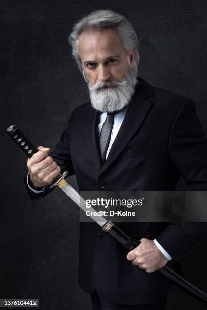 classy dressed senior businessman with knight sword - samurai sword stock pictures, royalty-free photos & images