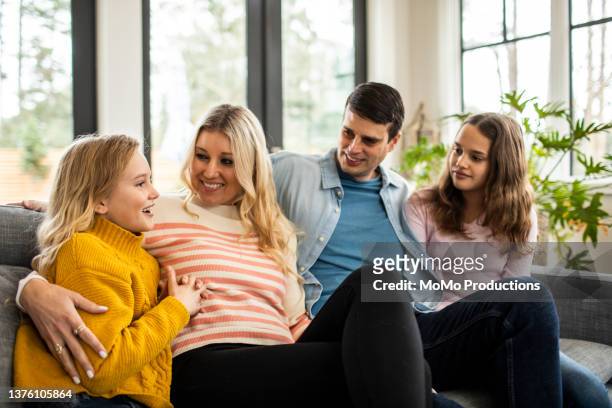 portrait of family on couch in modern home - kind vor der pubertät stock-fotos und bilder