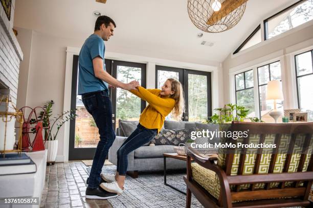 tween daughter dancing on her fathers feet in living room - father daughter dance stock-fotos und bilder