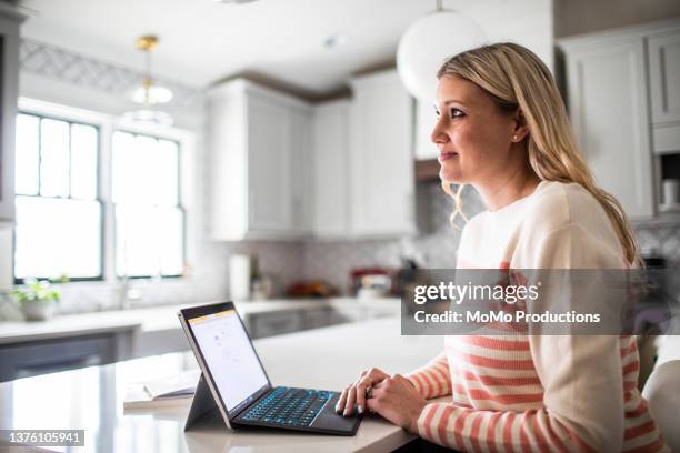 portrait of woman working from home in modern kitchen - woman portrait kitchen laptop bildbanksfoton och bilder