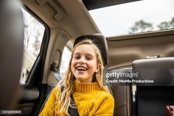 tween girl laughing in back seat of automobile - passagerarsäte bildbanksfoton och bilder