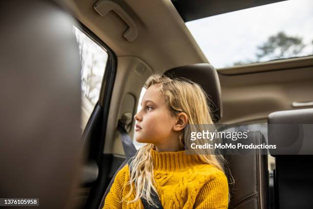 tween girl sitting in back seat of automobile - sicherheitsgurt teil eines fahrzeugs stock-fotos und bilder