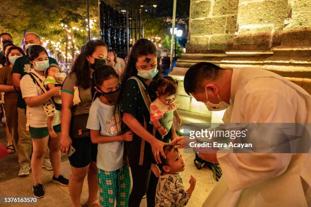 Filipinos take part in an Ash Wednesday mass as the Manila Cathedral is lit in the colors of the Ukraine flag on March 02, 2022 in Manila,...