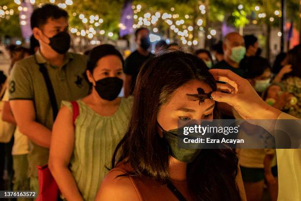 Filipinos take part in an Ash Wednesday mass as the Manila Cathedral is lit in the colors of the Ukraine flag on March 02, 2022 in Manila,...