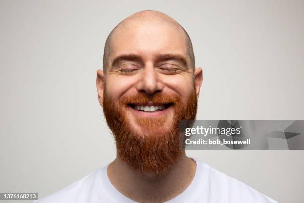 portrait of a young caucassian man closing eyes and smiling - met de ogen dicht stockfoto's en -beelden