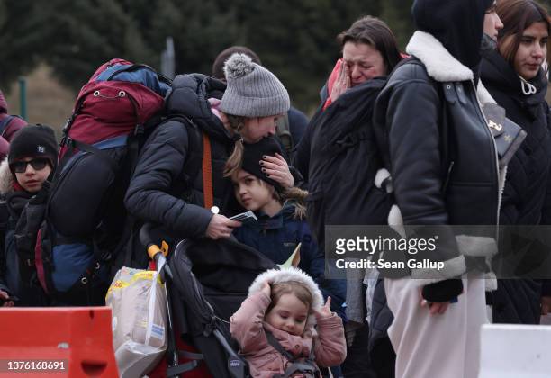 Distraught women and children fleeing war-torn Ukraine wait to cross into Poland at the Korczowa crossing on March 02, 2022 near Korczowa, Poland....