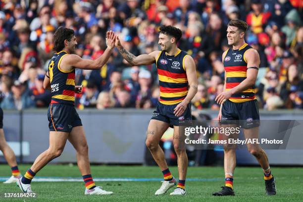 Josh Rachele, Izak Rankine and Ben Keays of the Crows celebrate a goal during the 2023 AFL Round 16 match between the Adelaide Crows and the North...