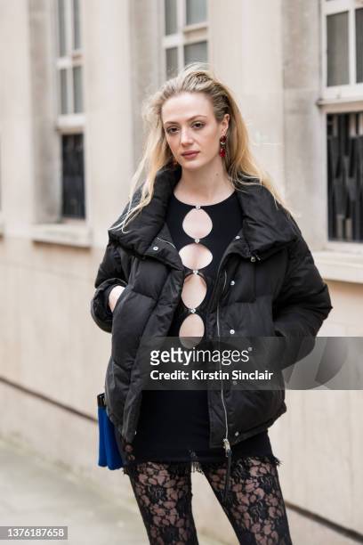 Georgie Fairhurst wears a Poster Girl top and trousers and a black down jacket during London Fashion Week February 2022 on February 18, 2022 in...