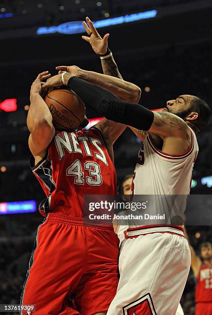 Carlos Boozer of the Chicago Bulls blocks a shot attempt by Kris Humphries of the New Jersey Nets at the United Center on January 23, 2012 in...