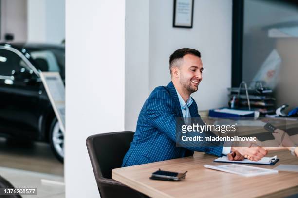 successful deal in a car showroom! - deal signing stockfoto's en -beelden