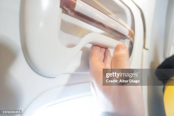 hand of a person at the emergency exit of an aircraft. - airplane open door stockfoto's en -beelden