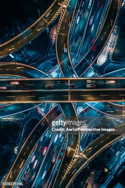 top view of overpass and road intersection at night - auto industrie stock-fotos und bilder