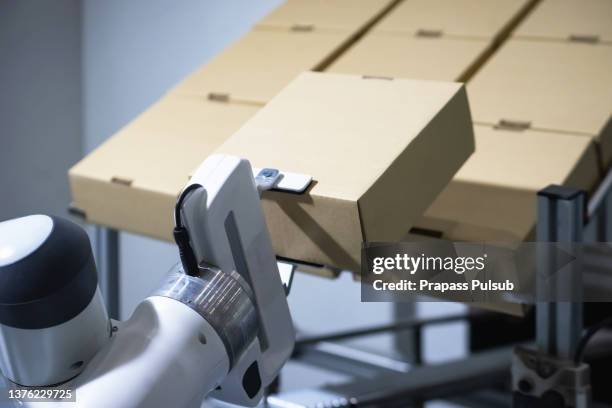 robot is working by pick the box to packing in manufacturing factory concept - boxes conveyor belt stock pictures, royalty-free photos & images