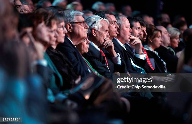 People listen as Republican presidential candidates, former U.S. Sen. Rick Santorum, former Massachusetts Gov. Mitt Romney, former Speaker of the...