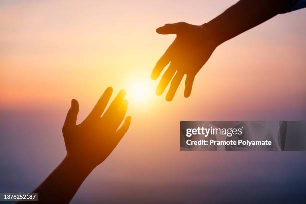 silhouette of helping hand concept and international day of peace. how can i help you. international day of peace.develop a friendship. please help me. helping hand - forgive stock-fotos und bilder